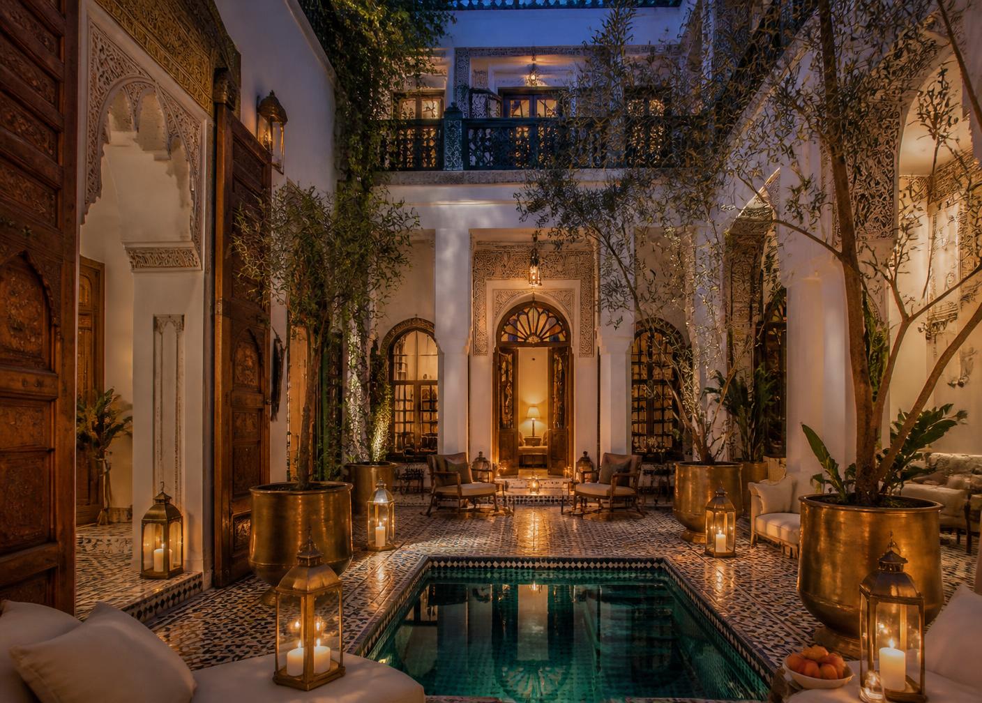 Candlelit courtyard of a restored luxury riad in Marrakech with zellige tiling and a plunge pool